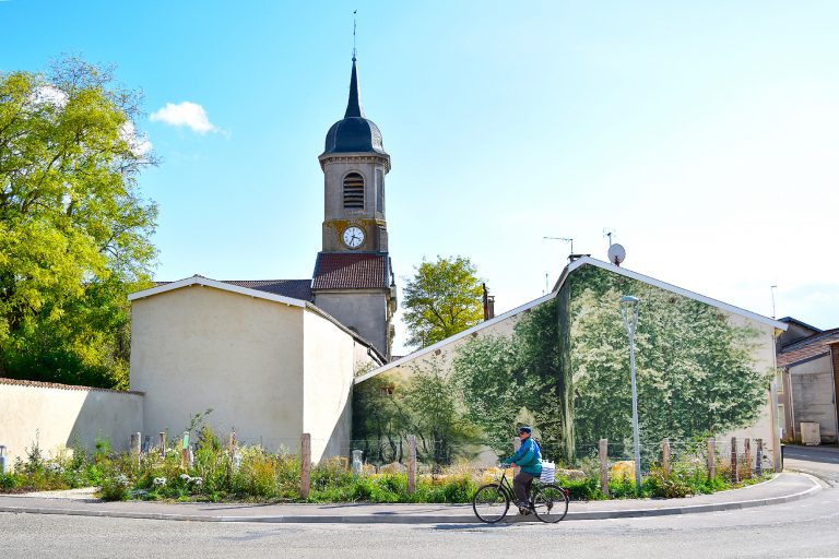 Photographie de la peinture La Révérence, sur le mur d'un bâtiment, devant l'église