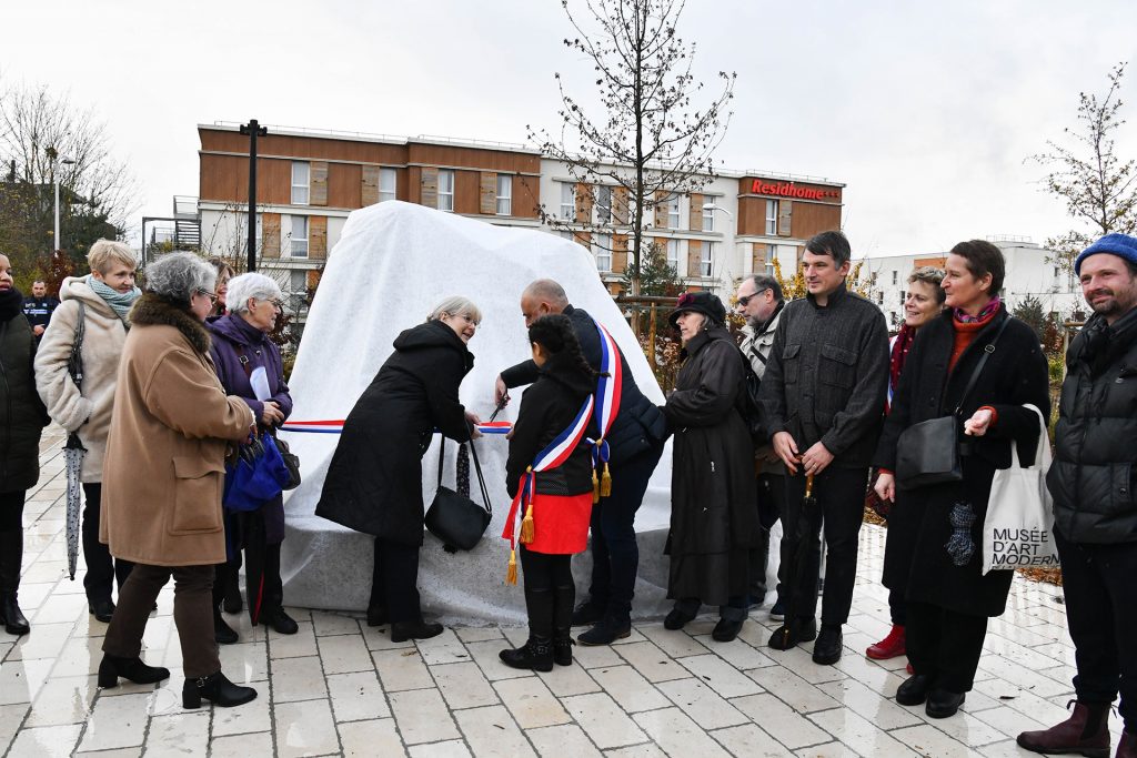 Les commanditaires, les artistes, la médiatrice, le maire et les élu·es de Guyancourt devant l’œuvre couverte, durant l’inauguration.