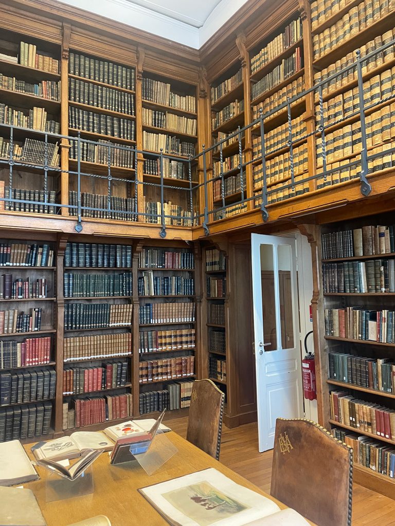 Intérieur de la bibliothèque de l'Institut Agro Rennes, présentant une table de lecture entourée d'une collection de livres.