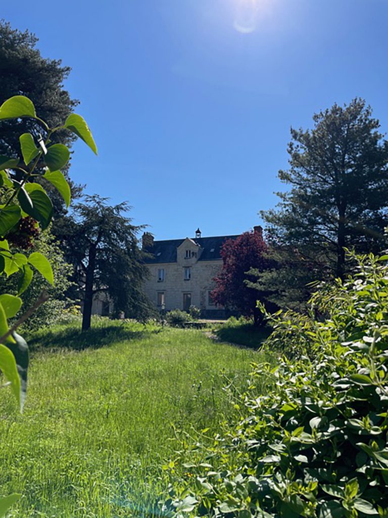 Photographie du Prieuré, ancienne maison de la Comtesse, depuis le fond d'un jardin.