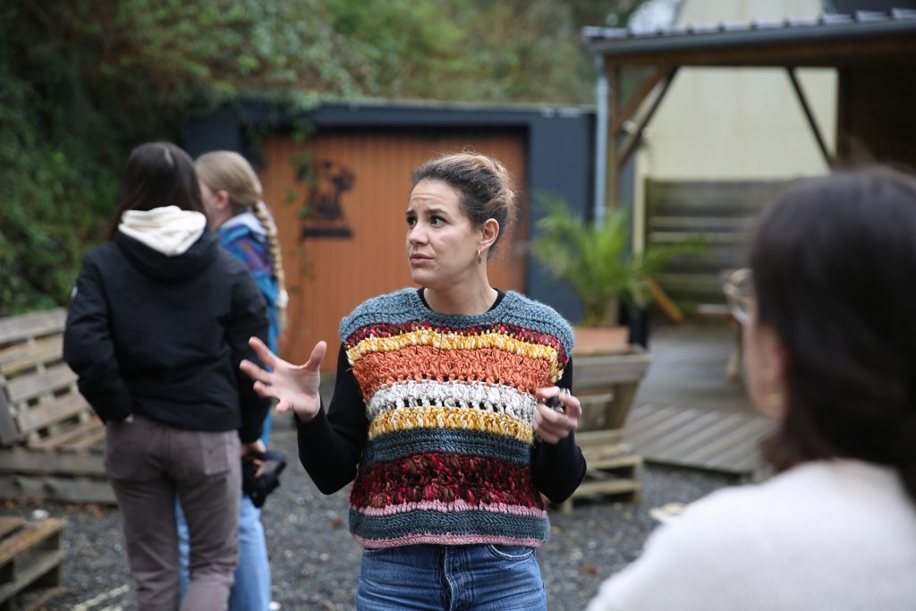 Clélia Le Meur, commanditaire et exploitant du bar-tabac-restaurant Maison Blanche, échange avec des personnes lors de la visite de la dernière maison du quartier.