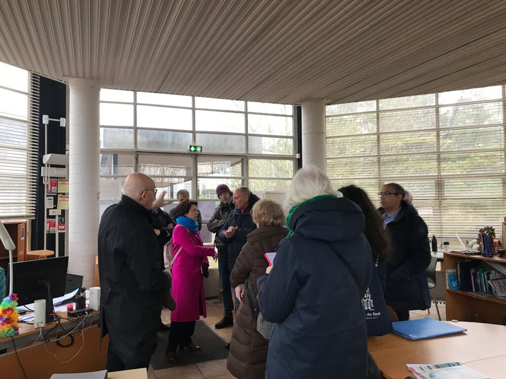 Le groupe de commanditaires dans l’entrée d’un bâtiment du futur site, lors de la visite en mars 2023.