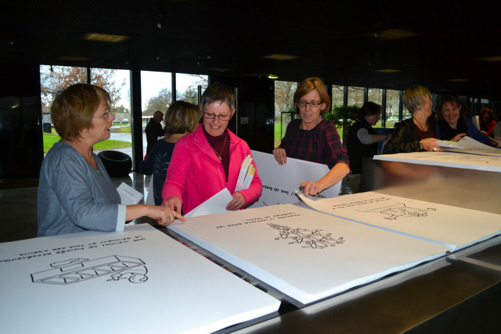 Agent·es des services de la Direction de la culture du Département d’Ille-et-Vilaine. Chacun·e est convié·e à sélectionner les formats et médiums d'impression qu'ielles souhaitent garder. Des dessins au format d'affiche sont proposés.