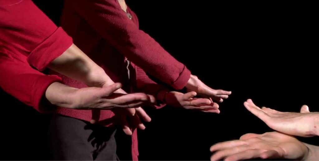 Deux paires de mains se frottent l'une contre l'autre. Elles semblent communiquer entre elles.