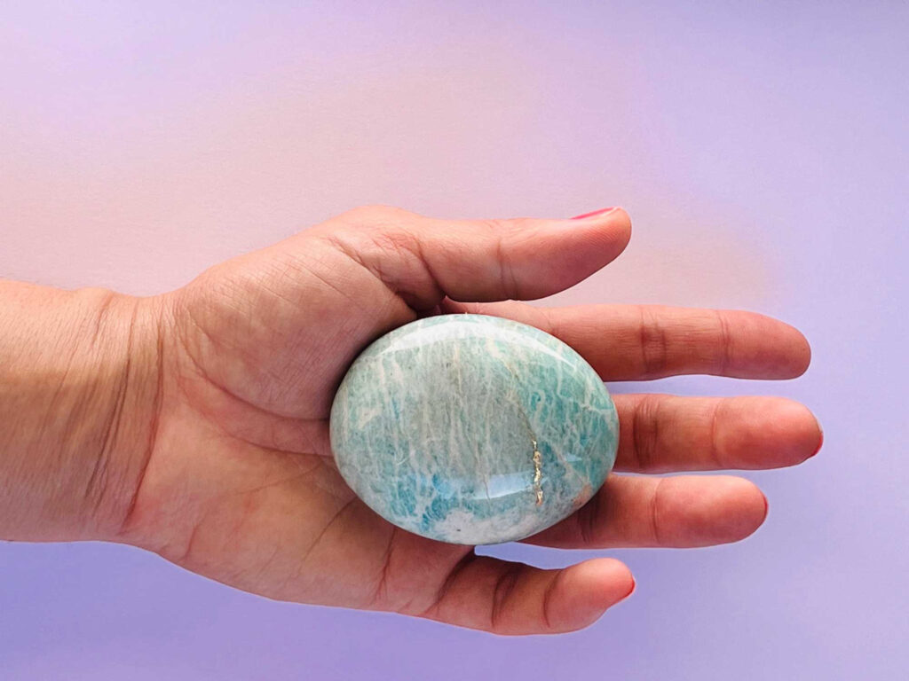 Galet lisse bleuté avec quelques touches blanches et dorées.